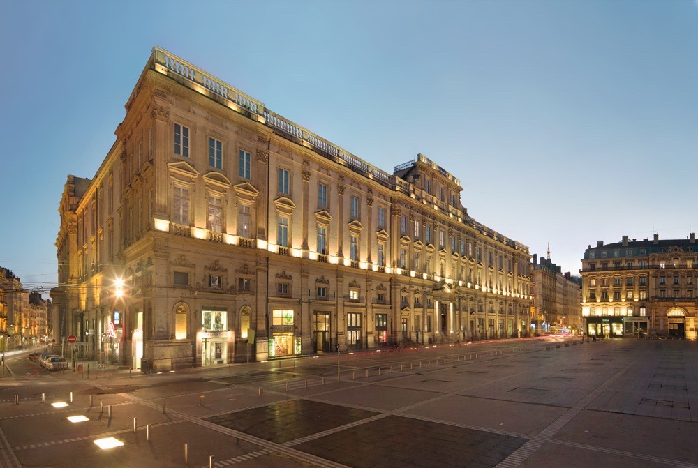 La façade du Musée des Beaux-Arts de Lyon éclairée à la tombée de la nuit, vue depuis la place des Terreaux.